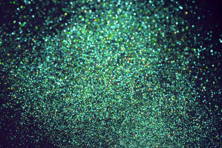 Vibrant green blurred sparkling glittering background. Festive backdrop.の写真素材