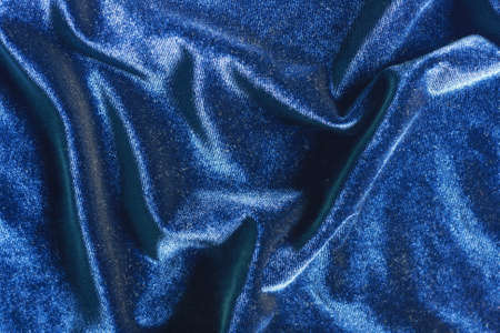 Deep blue shiny velvet folds texture background for designの写真素材