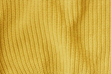 Yellow knitted woolen fabric textured background. Clothes or tissue for design.の写真素材