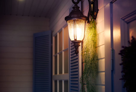 Vintage iron lantern on the wall outdoor in the evening. Exterior design elements.の写真素材