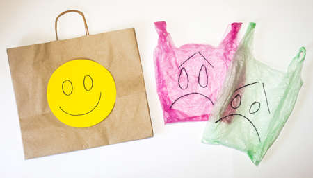 Plastic and paper bags with happy and sad emotions on faces against white background. Environment issue and plastic refusal concept.の写真素材