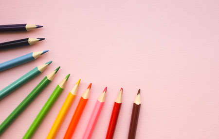 Colorful pencils of rainbow colors on pink pastel background, close up. Copy space.の写真素材