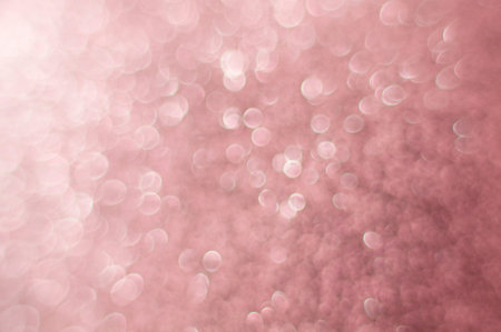 Pink glitter christmas abstract bokeh background. Blurred sparkles festive backdrop