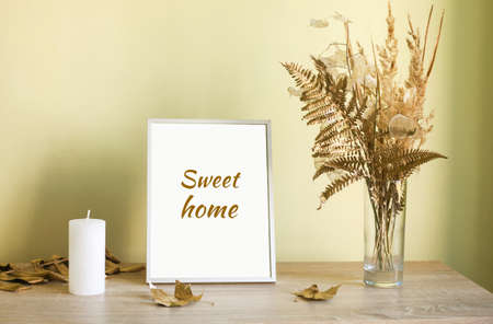 Dry yellow and golden flowers in vase, candle and picture frame Sweet Home. Home Decoration details. Design of interior.の写真素材