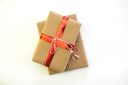 Christmas picture of two gift boxes wrapped with craft paper on white background. Festive minimal...