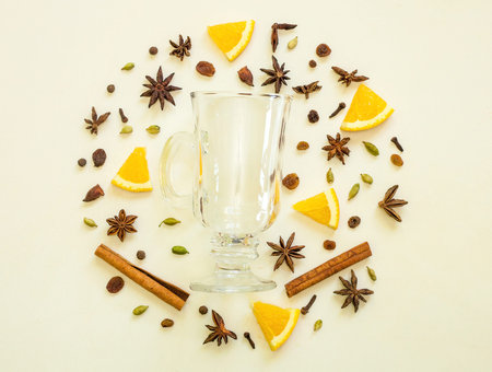 Mulled wine ingredients flat lay. Cinnamon, orange, cardamom, clove, anise and red wine on white background. Composition of traditional winter drink.の写真素材