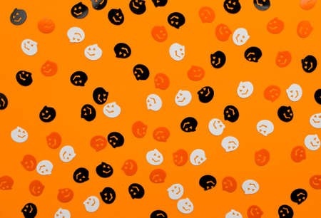 Halloween autumn holiday background with pumpkin confetti against orange. Copy space, top view, flat lay.の写真素材