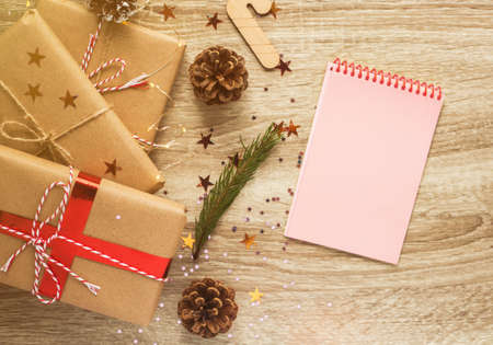 Christmas decorations and notebook on brown wood texture. Concept of Christmas or New Year list of wishes and decisions. Top view, flat lay.の写真素材