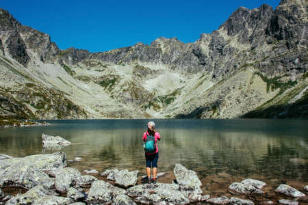 Mountain lake picturesque scenery. High rocks. Beautiful landscape. Slovakia, Tatry. Woman traveller.の写真素材
