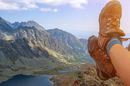 Mountain lake picturesque scenery. High rocks. Beautiful landscape. Slovakia, Tatry. Legs of travelling woman.の写真素材