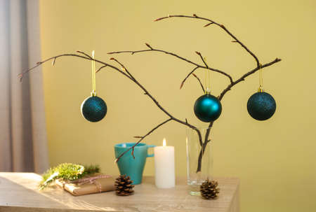 Christmas home decorations. Blue balls, branch of tree, gift box, candle, pine cones, DIY idea for interior design. Blue, white and brown colors.の写真素材