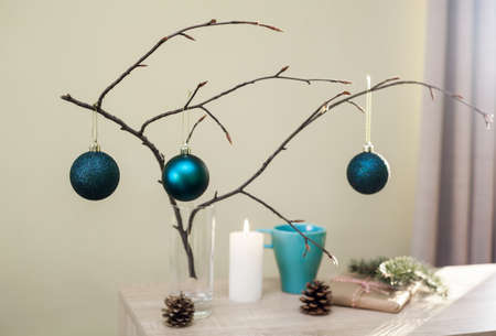 Christmas home decorations. Blue balls, branch of tree, gift box, candle, pine cones, DIY idea for interior design. Blue, white and brown colors.の写真素材