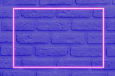 Vibrant blue brick wall layout and pink neon glowing frame. Flat lay. Vapor wave retro pattern for design. Ultra violet colors.の写真素材