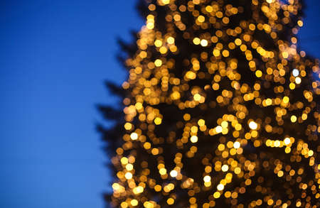 Defocused background of the European Christmas market. Blurred people in the night and bokeh of festive lightsの写真素材