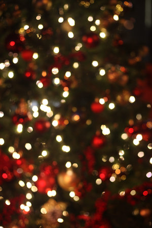 Blurred defocused picture of Christmas tree golden lights in the night, festive background for...