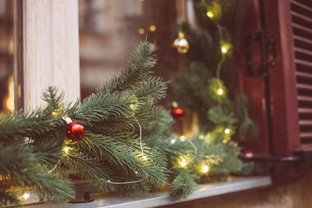 Christmas wreath, decorated window on door in winter made of tree branches, decor, balls and ribbons, holiday design ideaの写真素材