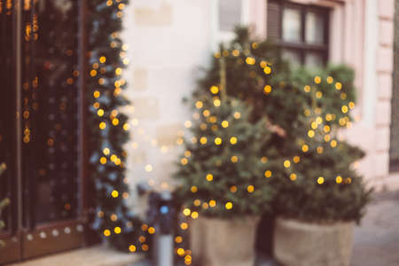 Defocused background. Beautiful golden evergreen Christmas trees at Christmas, decorated restaurant with lights and garlands, blurred backdropの写真素材