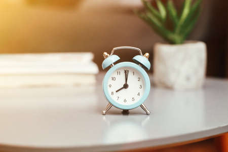 Alarm clock on blurred bedroom background in the morning, interior design details, concept of mornings, time, bedroom interiorの写真素材