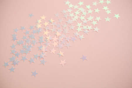 Pink background with pastel star shape confetti sparkles. Perfect festive background.の写真素材