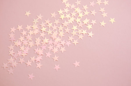 Pink background with pastel star shape confetti sparkles. Perfect festive background.の写真素材