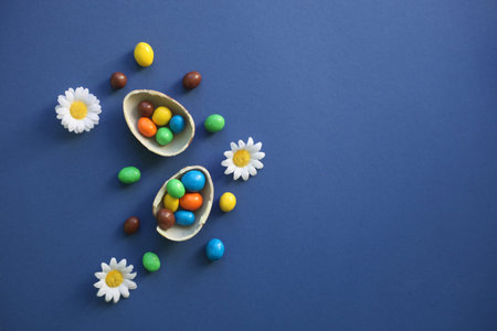 , Chocolate Easter Eggs with colorful candies over classic dark blue background, easter concept