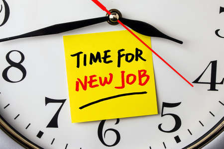 time for new job on note stuck to a wall clockの写真素材