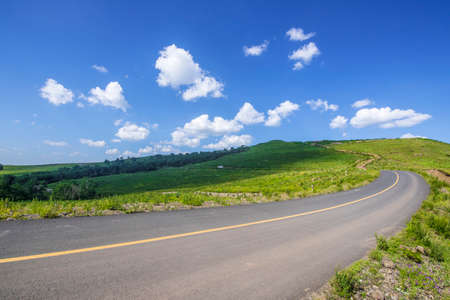empty asphalt road on grasslandの写真素材
