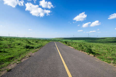empty asphalt road on grasslandの写真素材