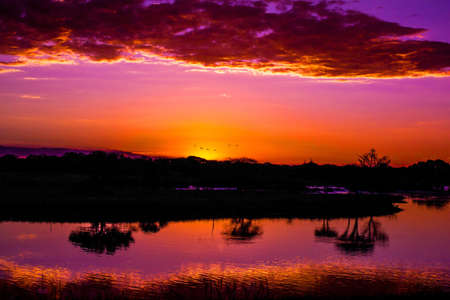 Orange Sunset over lake with clear reflectionsの写真素材