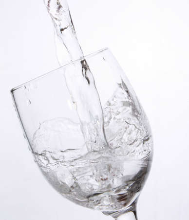 Crystal glass with splash of clear waterの写真素材