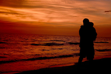  Dreaming kid on the hands of his father by the ocean at sunset time.の写真素材