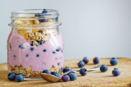 yogurt in glass with cereals and blueberriesの写真素材