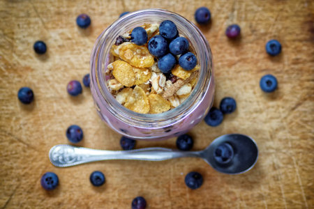yogurt in glass with cereals and blueberriesの写真素材