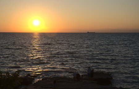 Sunset over the sea with a small ship in the distance.の写真素材