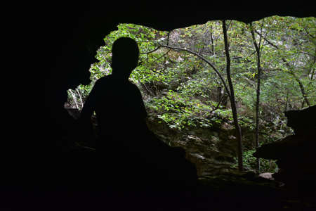 A silhouette of a woman in a cave mouthの写真素材