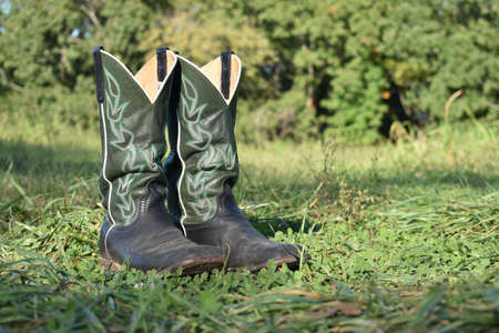 green cowboy boots in the grassの写真素材
