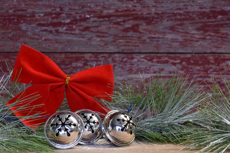 jingle bells and a red bow with a red barn board background