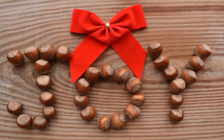 JOY spelled with hazelnut with a red bowの写真素材
