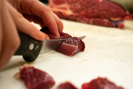 chopping red meat on a cutting board