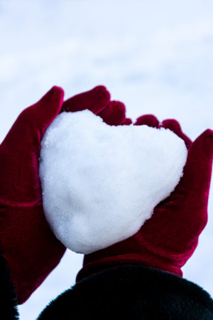 Holding a heart shaped snow ball