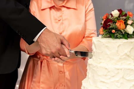 a couple cutting their wedding cakeの写真素材