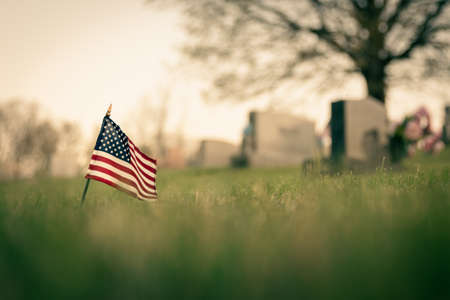 gravestones in the cemetery with a flagの写真素材
