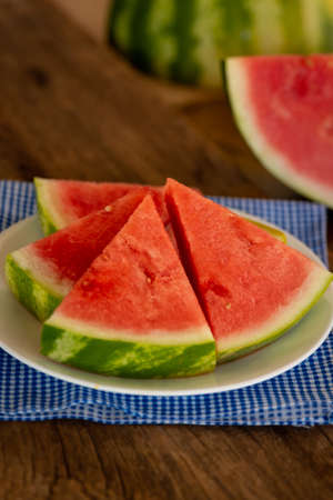 a plate of fresh watermelon with a blue napkinの写真素材