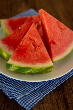 a plate of fresh watermelon with a blue napkinの写真素材