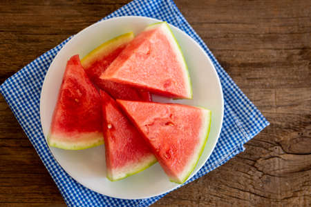 a plate of fresh watermelon with a blue napkinの写真素材