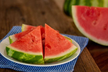 a plate of fresh watermelon with a blue napkinの写真素材