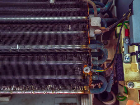 damaged air conditioner evaporator coils panel with dust contaminated and bent fins before maintenance and cleaning by closeup rusty steel and aluminium oxideの写真素材