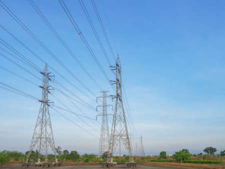 high voltage transmission towers with power line over blue sky and white cloud background the electricity infrastructure from power plant to industrial and householdの写真素材