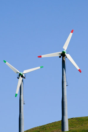 Two wind mills against a bright blue sky