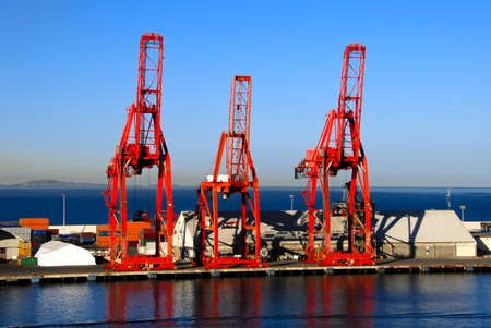 Bright red shipping cranes in Ensenada, Mexico with shipping containersのeditorial素材